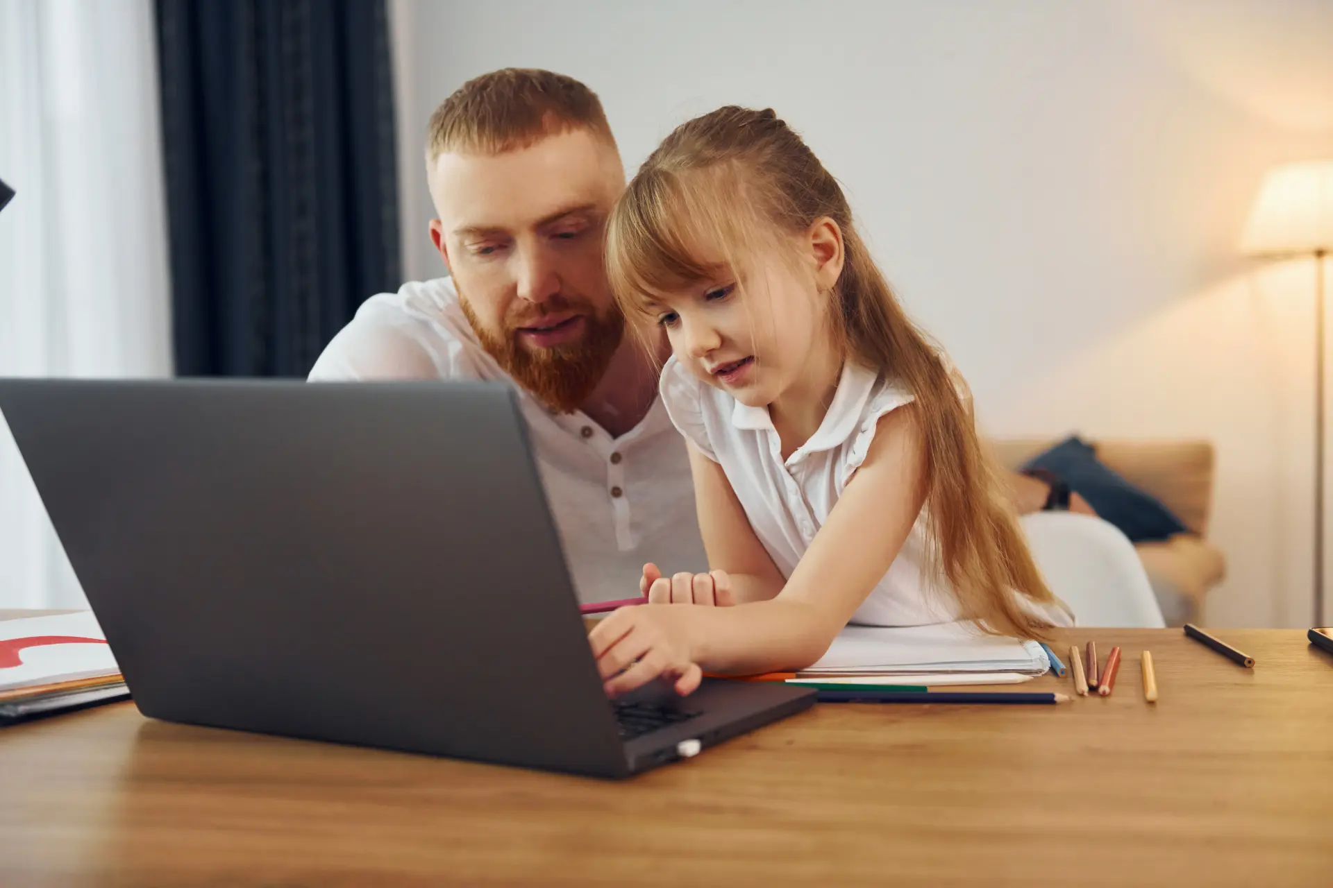 Apa és lánya tanul laptopon