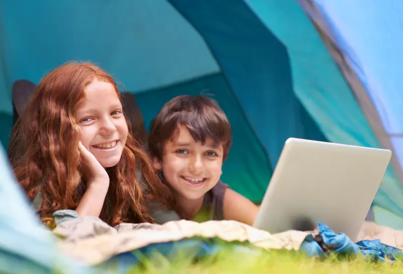 Önbizalommal tanuló fiú és lány a laptopon lévő matematikai feladatok mellett